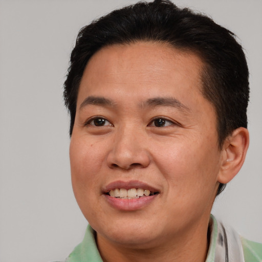 Joyful asian adult male with short  brown hair and brown eyes