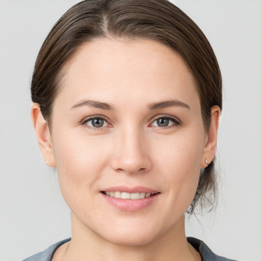 Joyful white young-adult female with medium  brown hair and grey eyes