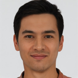 Joyful latino young-adult male with short  black hair and brown eyes