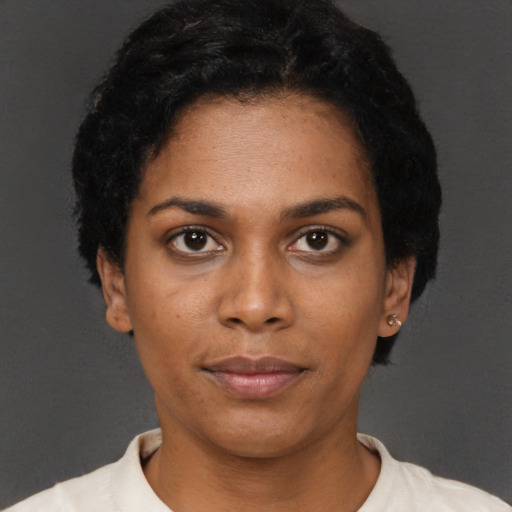 Joyful black young-adult female with short  black hair and brown eyes