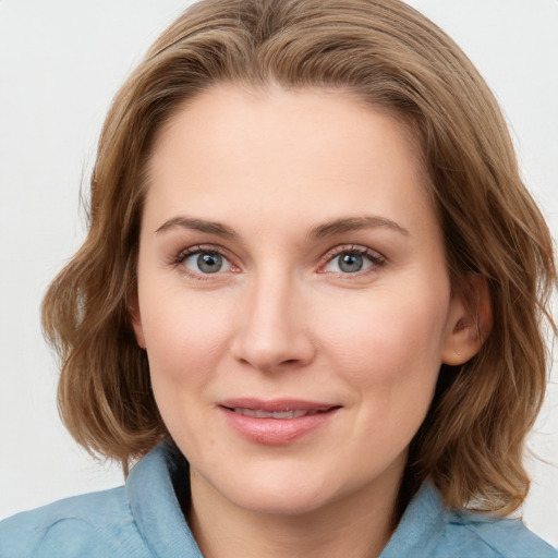 Joyful white young-adult female with medium  brown hair and blue eyes