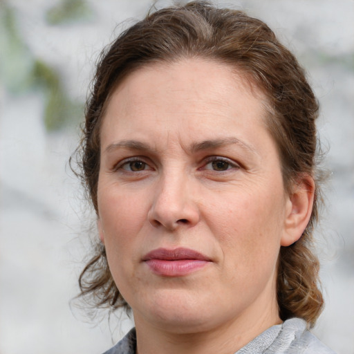 Joyful white adult female with medium  brown hair and grey eyes