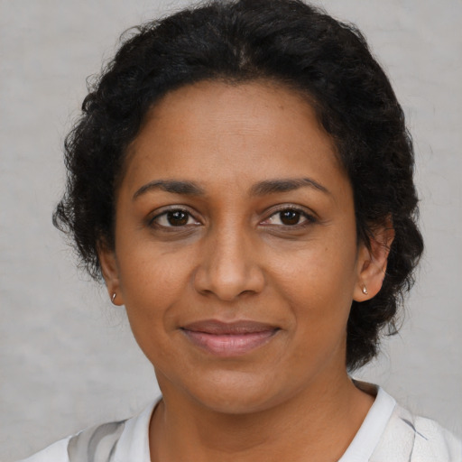 Joyful black adult female with short  brown hair and brown eyes