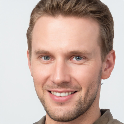 Joyful white young-adult male with short  brown hair and grey eyes