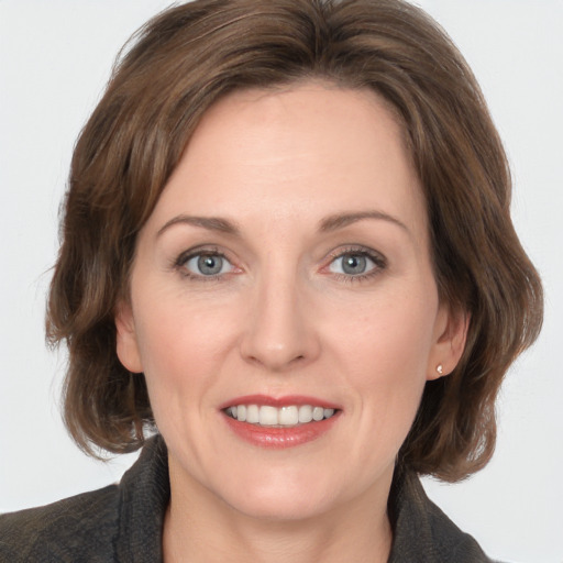 Joyful white adult female with medium  brown hair and grey eyes