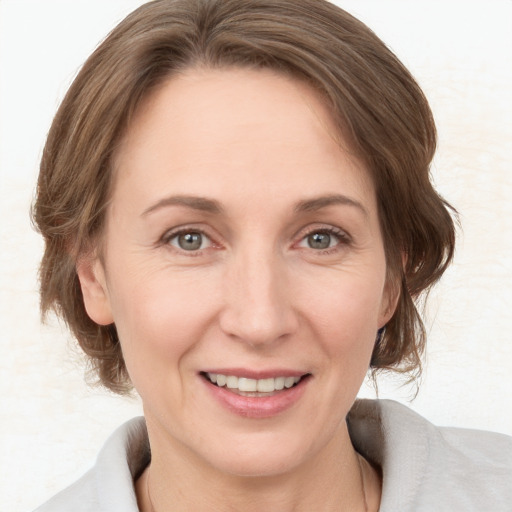 Joyful white adult female with medium  brown hair and grey eyes