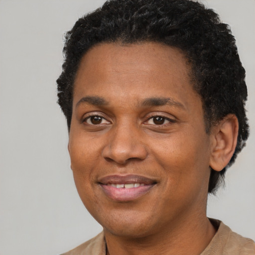 Joyful black young-adult male with short  black hair and brown eyes