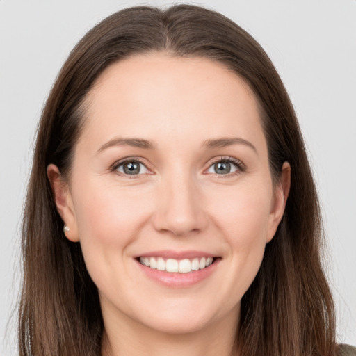 Joyful white young-adult female with long  brown hair and grey eyes