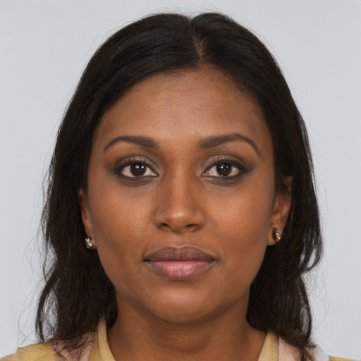Joyful black young-adult female with long  brown hair and brown eyes