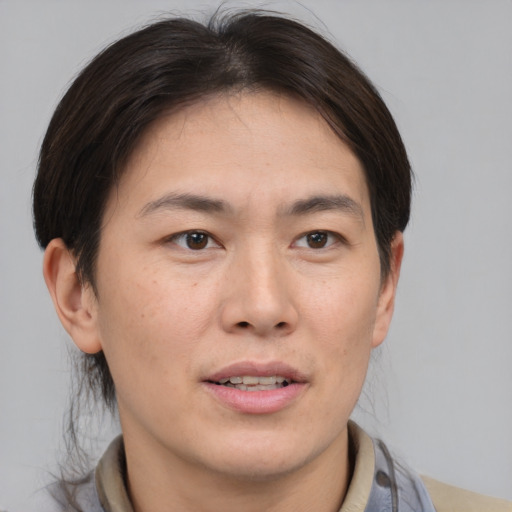 Joyful asian young-adult male with short  brown hair and brown eyes