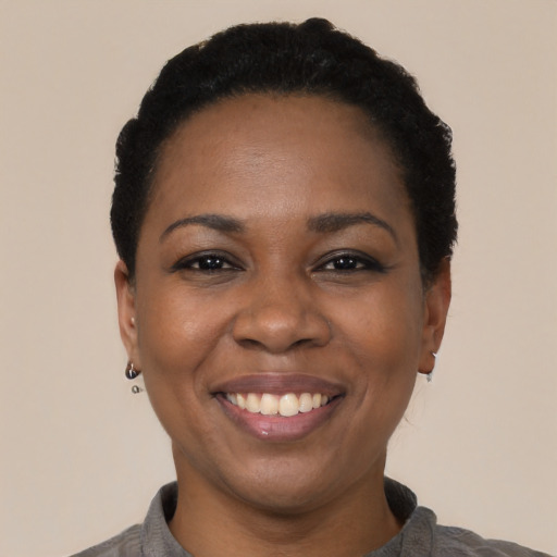 Joyful black young-adult female with short  black hair and brown eyes