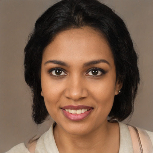Joyful black young-adult female with medium  brown hair and brown eyes