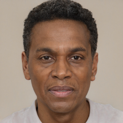 Joyful black adult male with short  black hair and brown eyes