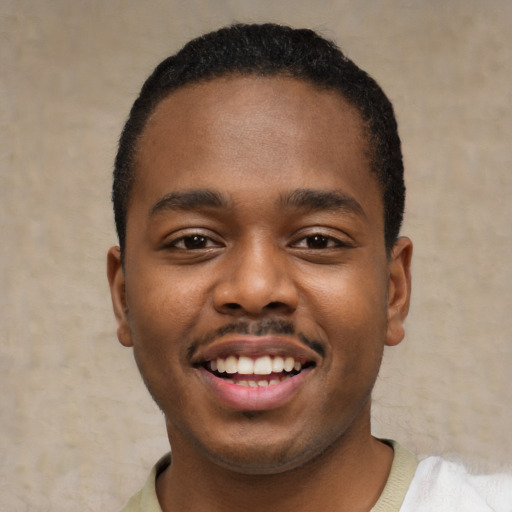 Joyful black young-adult male with short  black hair and brown eyes