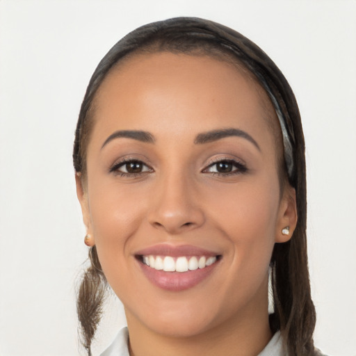 Joyful latino young-adult female with long  brown hair and brown eyes