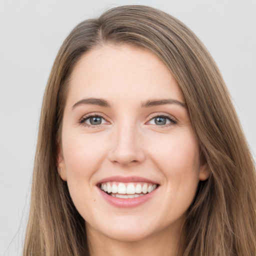 Joyful white young-adult female with long  brown hair and grey eyes