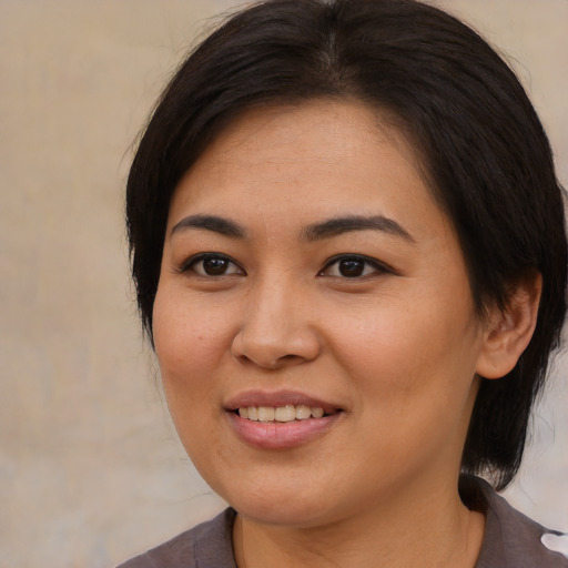 Joyful asian young-adult female with medium  brown hair and brown eyes