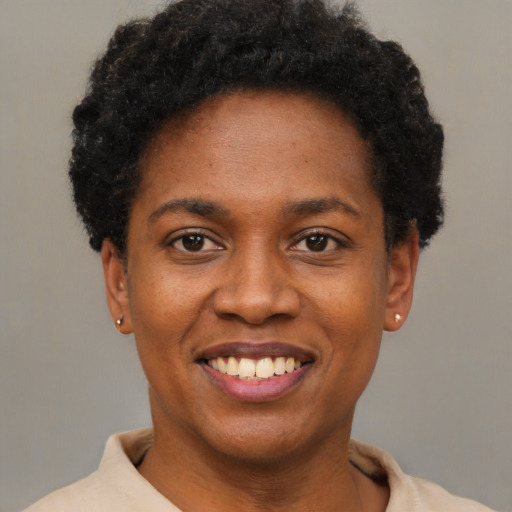 Joyful black young-adult female with short  black hair and brown eyes