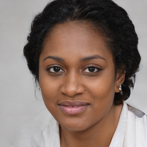 Joyful black young-adult female with long  black hair and brown eyes