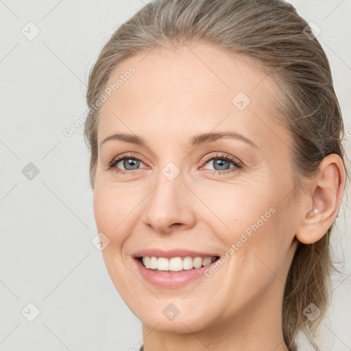 Joyful white adult female with medium  brown hair and grey eyes