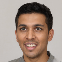 Joyful latino young-adult male with short  black hair and brown eyes