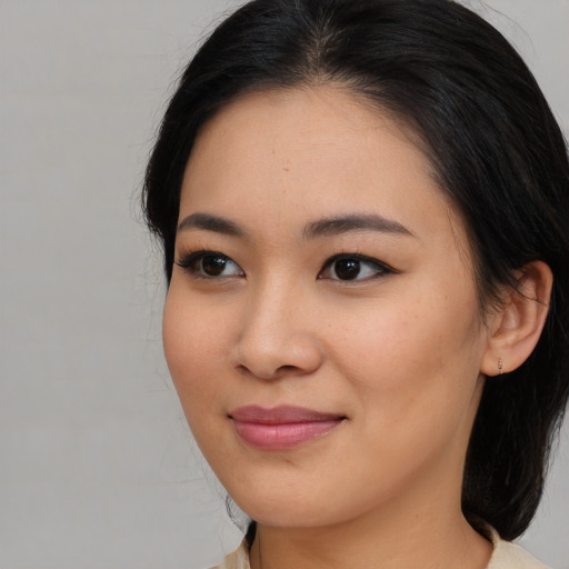 Joyful asian young-adult female with medium  brown hair and brown eyes