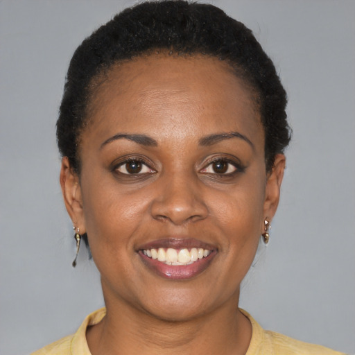 Joyful black young-adult female with short  black hair and brown eyes