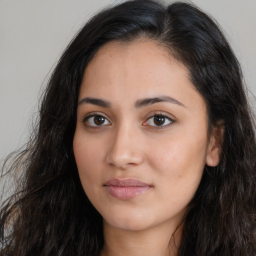 Joyful latino young-adult female with long  brown hair and brown eyes