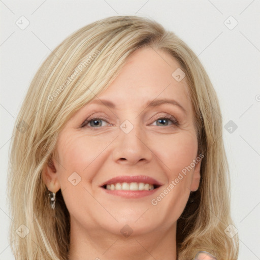 Joyful white adult female with long  brown hair and blue eyes