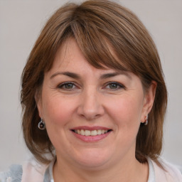 Joyful white adult female with medium  brown hair and blue eyes