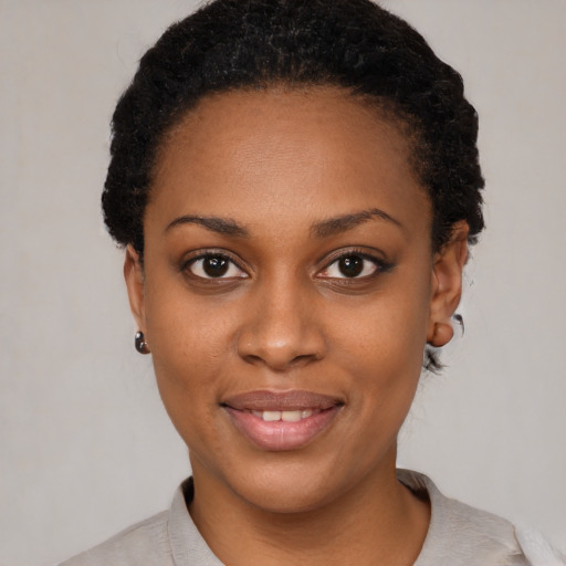 Joyful black young-adult female with short  black hair and brown eyes