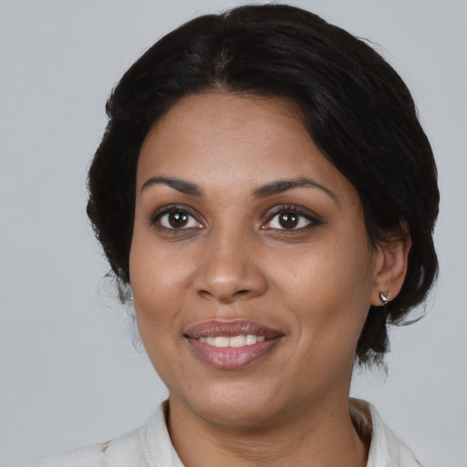 Joyful black adult female with medium  brown hair and brown eyes