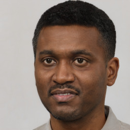 Joyful black young-adult male with short  black hair and brown eyes
