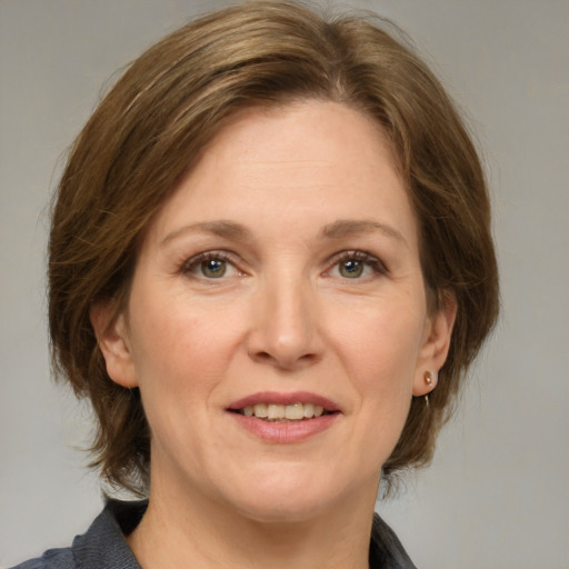 Joyful white adult female with medium  brown hair and grey eyes