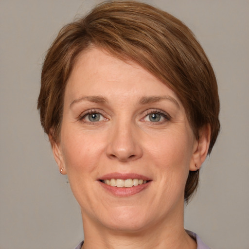 Joyful white adult female with medium  brown hair and grey eyes