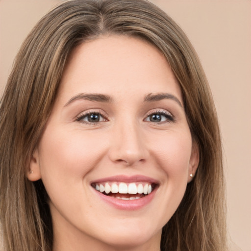 Joyful white young-adult female with long  brown hair and green eyes