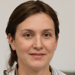 Joyful white adult female with medium  brown hair and grey eyes