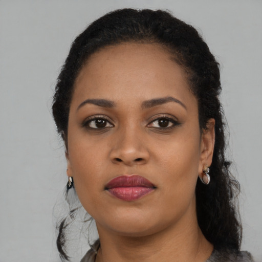 Joyful black young-adult female with long  black hair and brown eyes