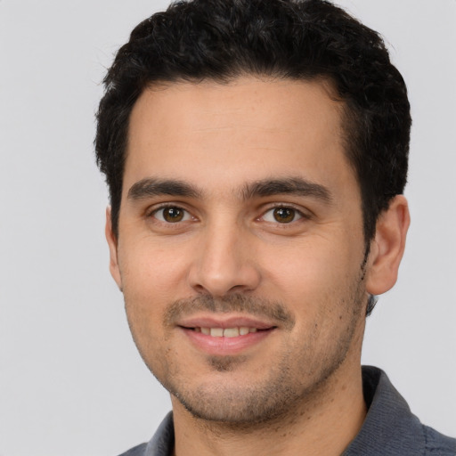 Joyful white young-adult male with short  black hair and brown eyes