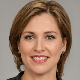 Joyful white young-adult female with medium  brown hair and green eyes