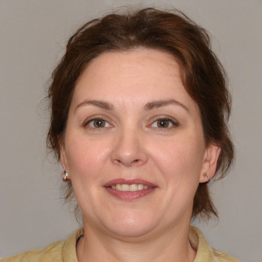 Joyful white adult female with medium  brown hair and brown eyes