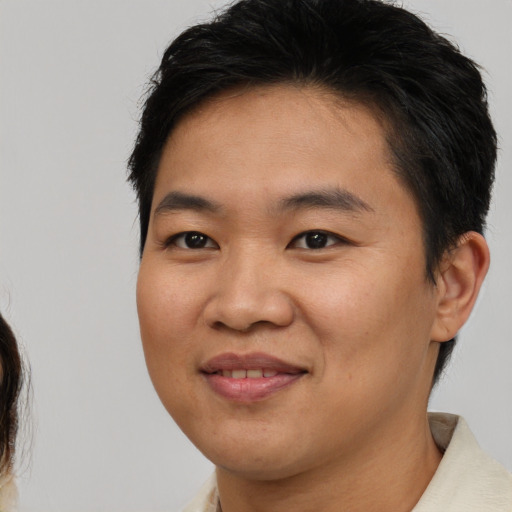 Joyful asian young-adult male with medium  brown hair and brown eyes