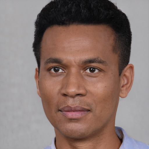 Joyful black young-adult male with short  black hair and brown eyes