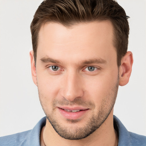 Joyful white young-adult male with short  brown hair and grey eyes