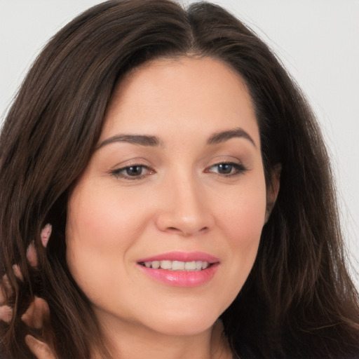 Joyful white young-adult female with long  brown hair and brown eyes