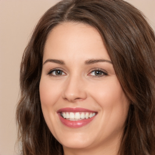 Joyful white young-adult female with long  brown hair and brown eyes