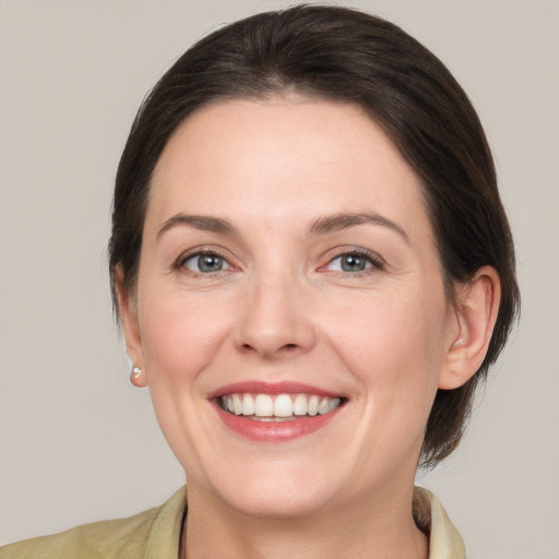 Joyful white young-adult female with medium  brown hair and grey eyes