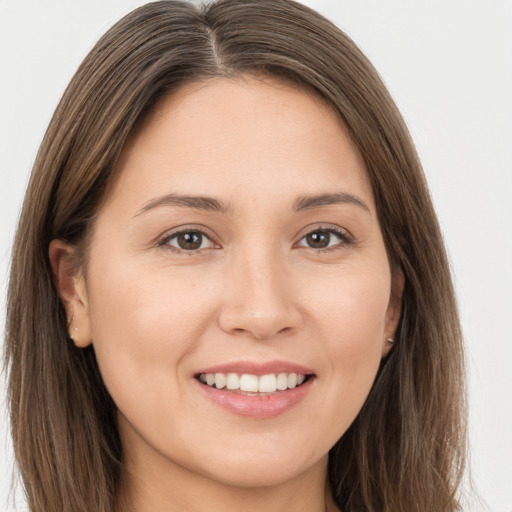 Joyful white young-adult female with long  brown hair and brown eyes