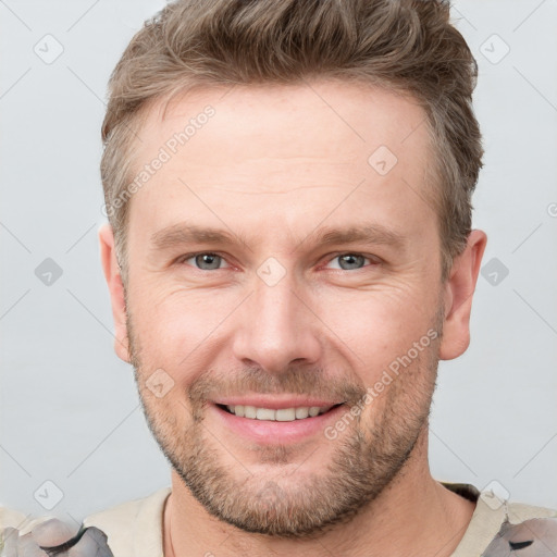 Joyful white adult male with short  brown hair and grey eyes