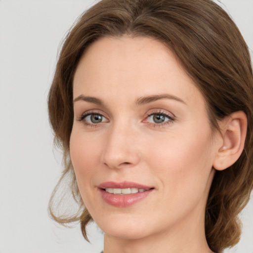 Joyful white young-adult female with medium  brown hair and grey eyes